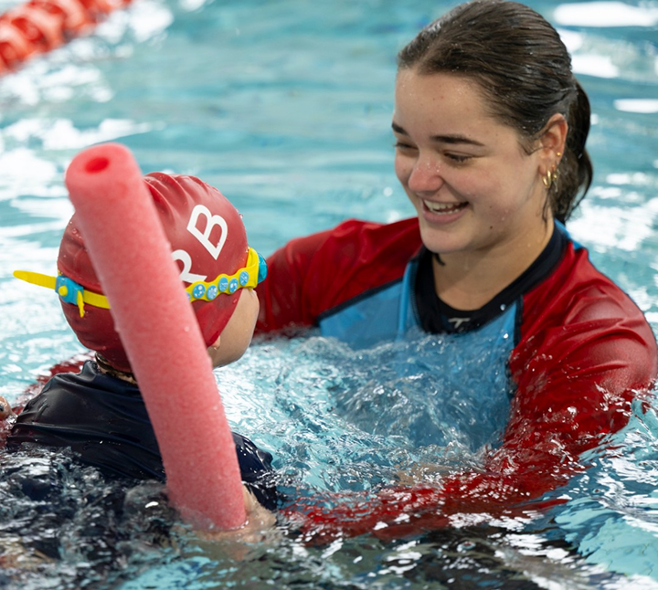 KRB instructor guiding a young child to swim